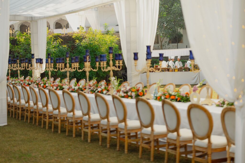Long dinner table under white tent drapes