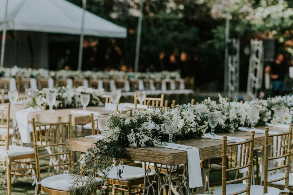 Long dinner tables under a white tent